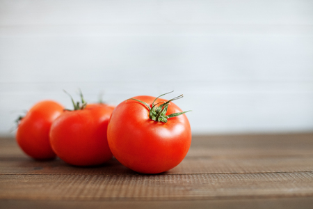 Tomatoes on a wooden table. The concept of healthy eating and vegetarianism.の写真素材
