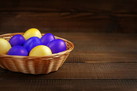 Yellow and purple Easter eggs in the basket. The concept of a holiday and a happy Easterの写真素材