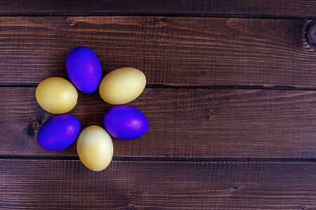 Colored Easter eggs on wooden background. The concept of a holiday and a happy Easterの写真素材