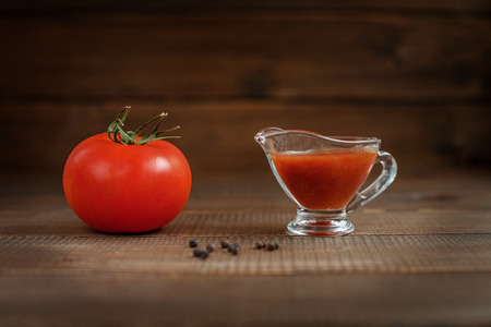 The sauce and tomato on a wooden table. The concept of healthy eating and vegetarianism.の写真素材