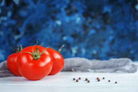 Tasty tomatoes and sweet peppers on a blue background. The concept of food and vegetarianism.の写真素材