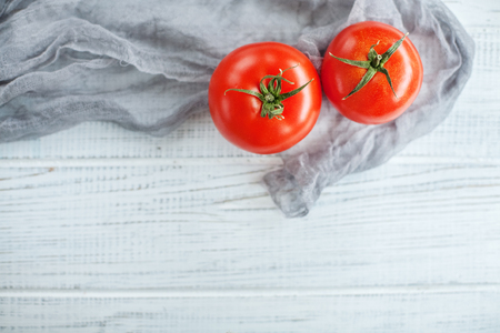 Tasty tomatoes on a white wooden background. The concept of food and vegetarianism.の写真素材