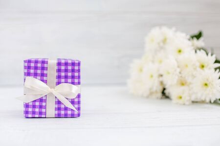 Violet box with a gift and flowers. The concept of Mother's Day, birthday, March 8.の写真素材