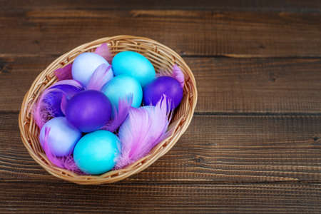 Colored eggs in a wicker basket. Concept Happy Easter.の写真素材