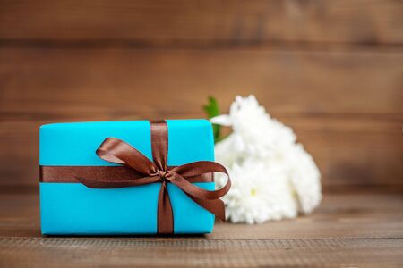 Wooden background with a gift and flowers. The concept of Mother's Day, birthday, March 8.の写真素材