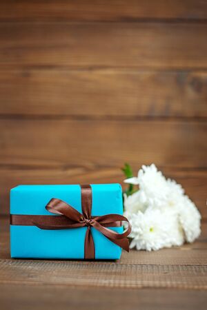 Wooden background with gift and white flowers. The concept of Mother's Day, birthday, March 8.の写真素材