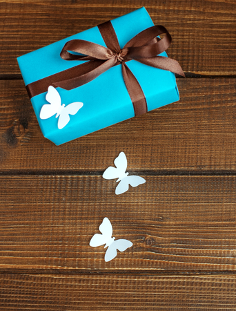 Wooden background with gift and butterflies. Top view.  The concept of Mother's Day, birthday, March 8.の写真素材
