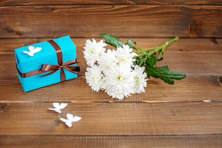 Wooden background with a gift and flowers and butterflies.  The concept of Mother's Day, birthday, March 8.の写真素材