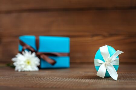 Egg and gift on a wooden background. Place for inscription. Concept Happy Easter.の写真素材