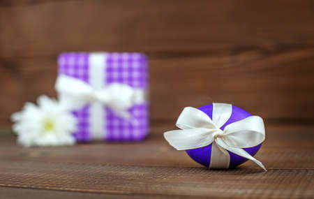 Egg and flower on a wooden background. Gift. Place for inscription. Concept Happy Easter.の写真素材