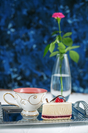 A cup of hot tea and cake on a blue background. The concept of drinks and food.の写真素材