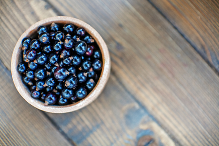 Useful berry. Black currants in a wooden bowl. Top view. The concept is healthy food, vitamins, diet and vegetarianism.の写真素材