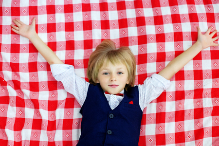 The boy is a schoolgirl lying on the bed. The concept of childhood and recreation.の写真素材