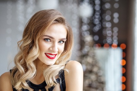 Portrait of a young woman with a red lipstick for Christmas. Concept of Happy Christmas and New Year, winter, party.の写真素材