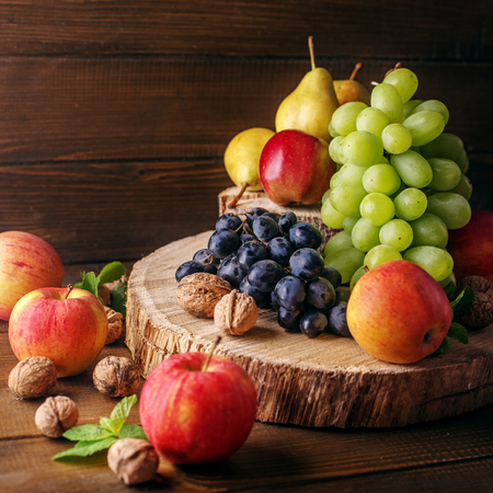 Still life of fruit, apples, pears, grapes and nuts. Copy space. The concept is healthy food, vegetarianism, vitamins.の写真素材