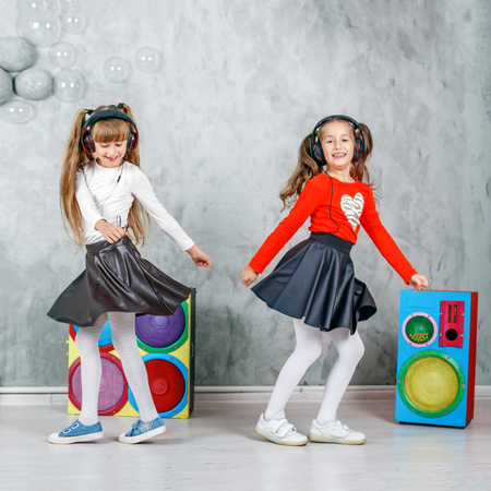 Funny children dance and listen to music in headphones. The concept is childhood, lifestyle, dance, music.の写真素材