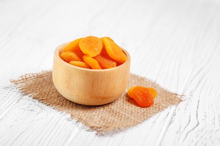 A lot of useful dried apricots in a wooden bowl. The concept is healthy food, vegetarianism, diet, vitamins.の写真素材