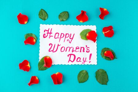 Blue background with greetings and petals of flowers. Concept of Happy Women's Day. Flat lay. Concept of Happy Women's Day.の写真素材