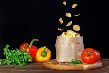 Tasty chips in the package. Peppers and tomatoes. The concept of food and delicious snacks.の写真素材