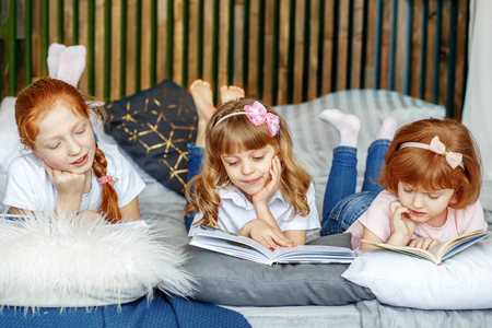 Three children lie and read books. The concept of lifestyle, childhood, education, family, school.の写真素材