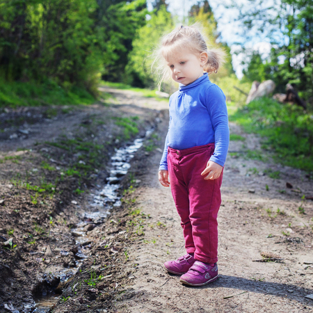 Little child looks at the creek in the woods. Square. Concept family, yoga, travel.の写真素材