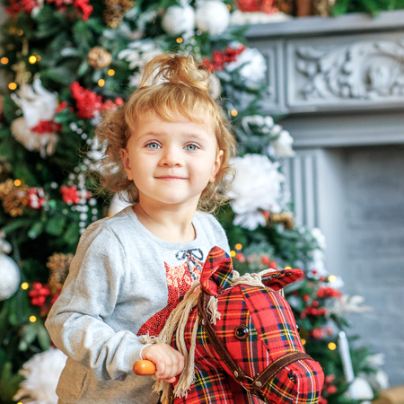 A 3 year old girl is playing in the room. Concept of Merry Christmasの写真素材