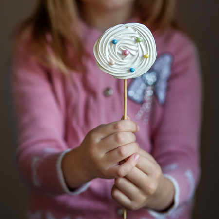 Candy on a stick in children's hands. The concept of sweets, party, bakeryの写真素材