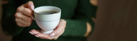 A cup of hot coffee in the hands. Concept drinks, lifestyle, work, background.の写真素材