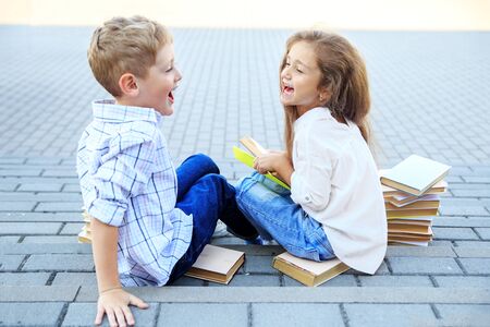 Happy boy and girl are reading books. The concept is back to school, education, reading, friendship and family.の写真素材