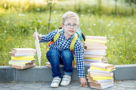 Little schoolboy with a backpack and books. Back to school. The concept of learning, school, mind, lifestyle and success.の写真素材