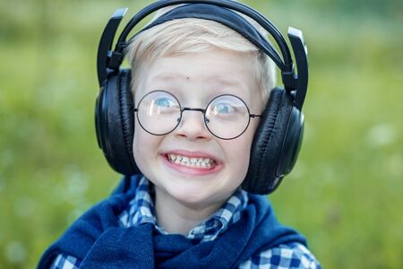 Cheerful little child listening to songs in headphones. The concept of music, education and lifestyle.の写真素材