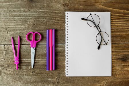 Pink stationery items on wooden background. The concept of school, creativity, childhood and work.