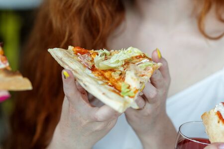 The girl eats a tasty slice of pizza. Concept of food, fast food, pizzeria.の写真素材