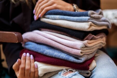 A very large assortment of hats in female hands. Fashion concept, stylist, knitted clothes.の写真素材
