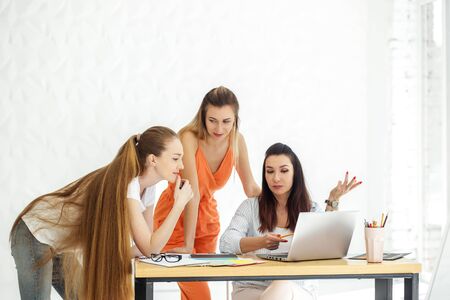 A group of women discusses a working draft in the office. Brainstorm. The concept of work, colleagues, meeting and work on the result.の写真素材
