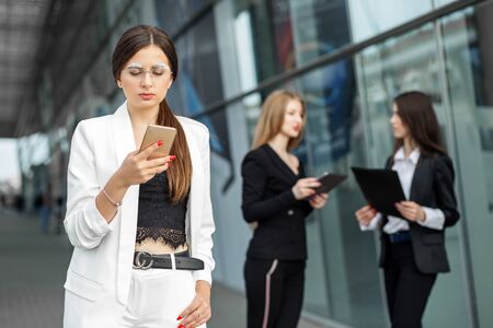 Young female boss reads messages on android. The concept of the Internet, technology, business, communication and lifestyle.の写真素材