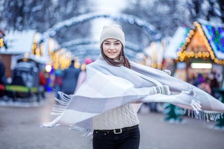 Happy young woman wearing a hat and a scarf. Concept Lifestyle, Urban, Winter, Vacation, Happy Christmas, New Yearの写真素材