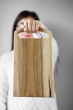 Kitchen board in female hands. The concept of food, menu, cooking.の写真素材