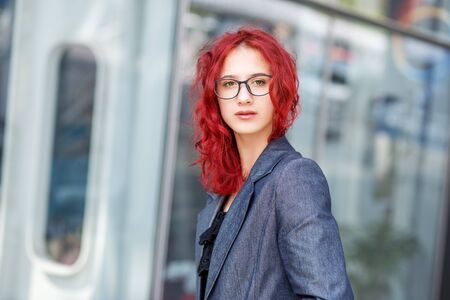 Girl with red hair wearing glasses. Gen z concept and study.の写真素材