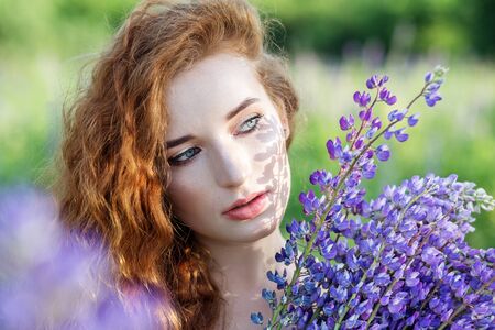Portrait of a beautiful woman. Sunlight. Wavy red long hair. Close-up. Concept slow life, organic cosmetics and digital detox.の写真素材