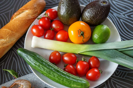 Vegetables plate. Organic food. Healthy food. Fresh vegetables on a white plate, avocado, shallots,...