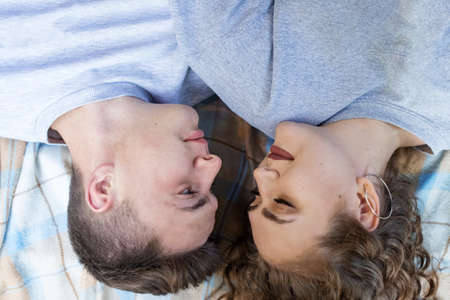A man and a woman lie side by side. Picnic in the fall. Romantic date of lovers. View from above.
