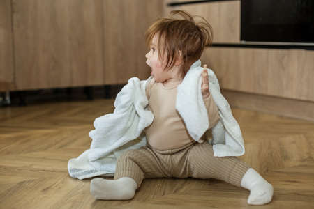 Toddler girl plays and has fun, hide-and-seek. Cozy house.の写真素材