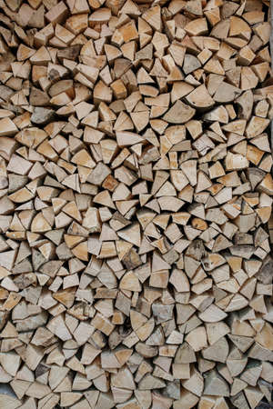 natural wooden background. Chopped firewood. Firewood is stacked and prepared for winter. Pile of...