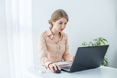 Female student uses laptop and Internet in studies. Comfortable working place