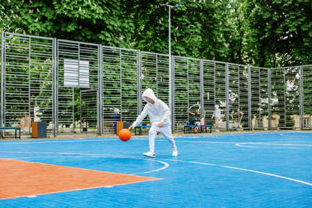 Concept of sports, hobbies and healthy lifestyle. Child schoolboy trains playing basketball on...