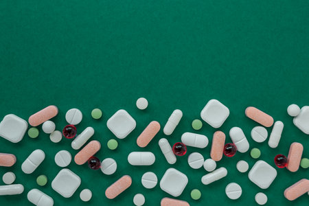 Many different pills on green background. Copy space. Top view. Concept of pharmaceuticals, medicine and healthcare.の写真素材