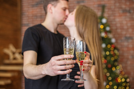 Cheers! Close up photo of two people holding glasses of shampagne on Christmasの写真素材