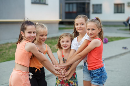 Group of girls children are playing in yard. Childhood, leisure and friendship concept