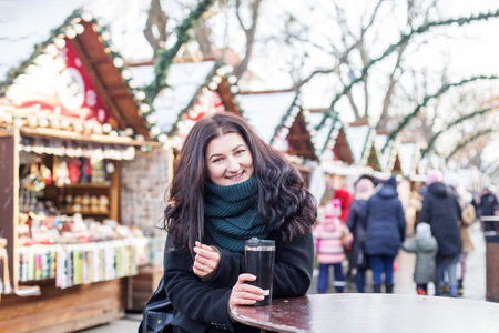 Happy woman buys gifts at festive Christmas market. Concept of winter holidays.の写真素材
